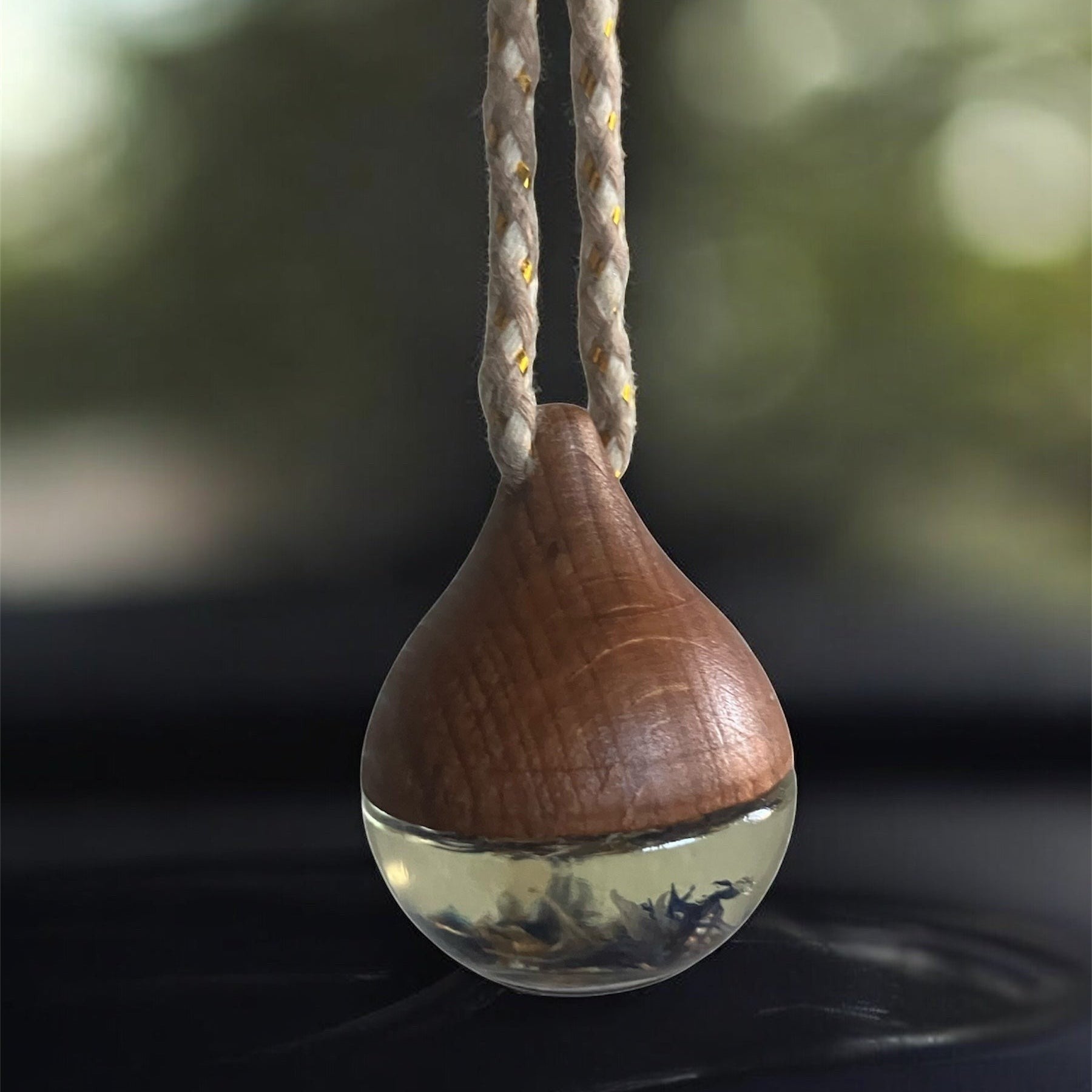 Decorative hanging car diffuser suspended from a rearview mirror, infused with premium essential oils, available in White Tea, Lemon Lavender Mint, Love Spell, and Energy scents for a fresh and calming driving experience.
