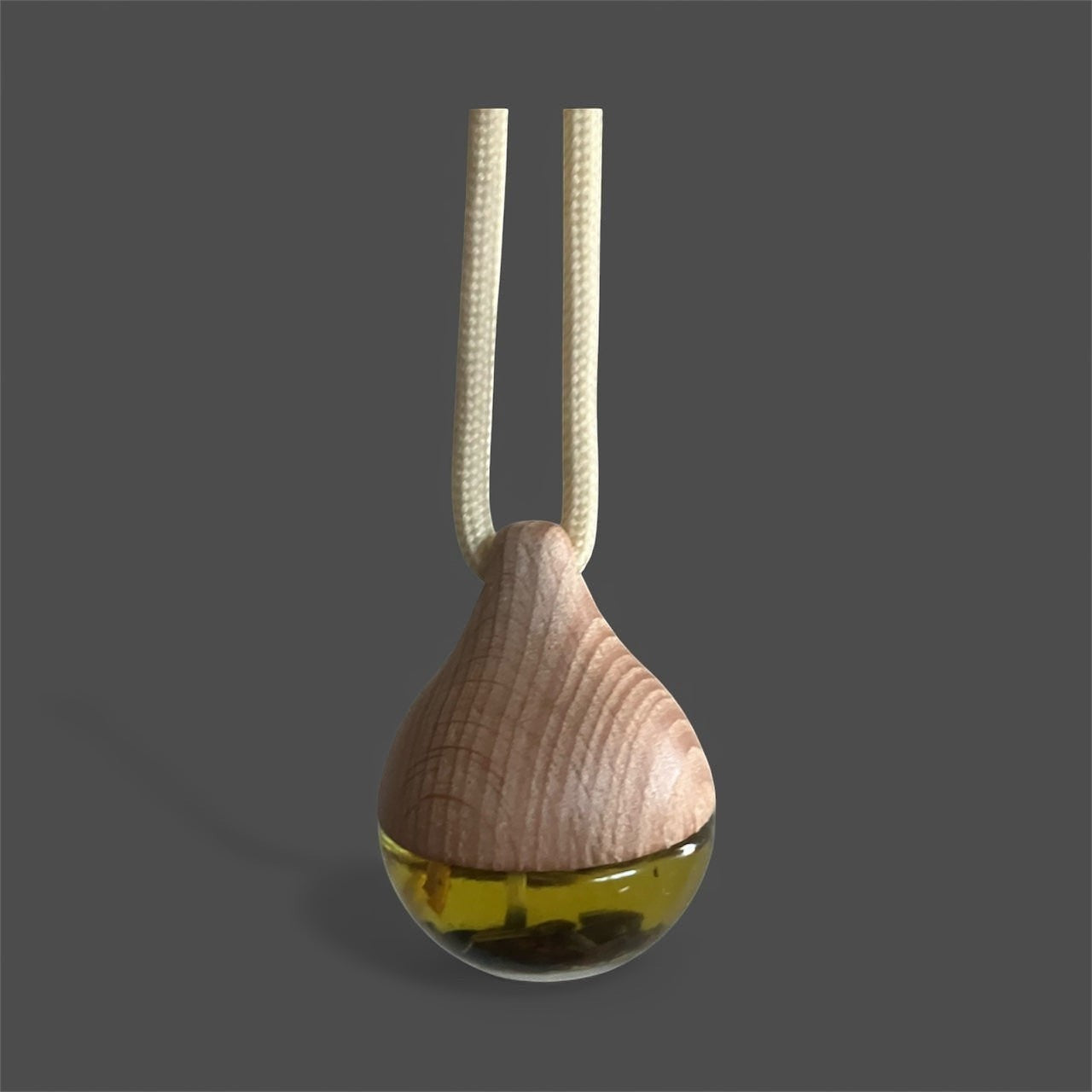 Decorative hanging car diffuser suspended from a rearview mirror, infused with premium essential oils, available in White Tea, Lemon Lavender Mint, Love Spell, and Energy scents for a fresh and calming driving experience.