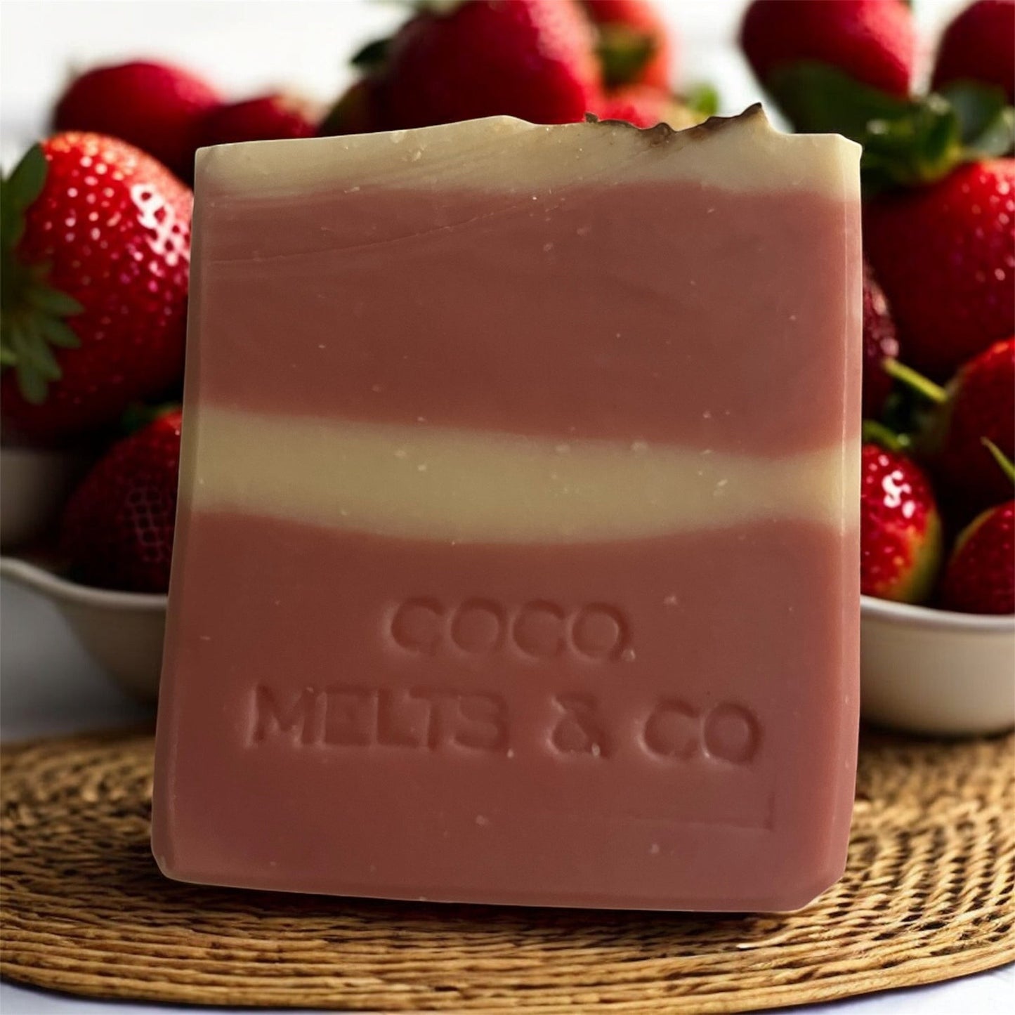 Handcrafted goat milk soap bar decorated with dried rose petals, scented with strawberry and Tahitian monoi essential oils, made with kaolin clay and mica for a soft, creamy lather