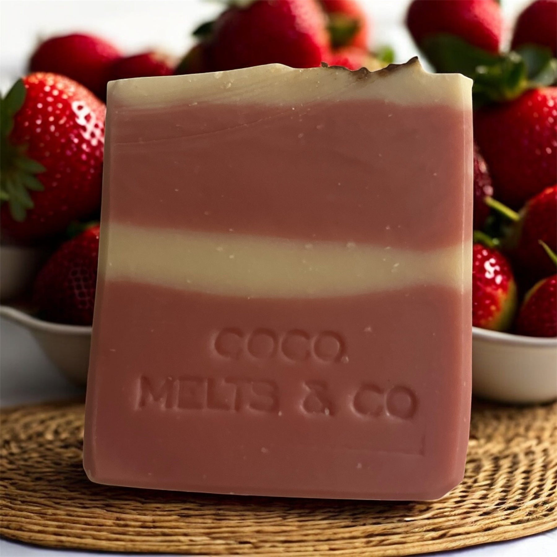 Handcrafted goat milk soap bar decorated with dried rose petals, scented with strawberry and Tahitian monoi essential oils, made with kaolin clay and mica for a soft, creamy lather