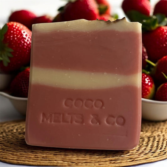 Handcrafted goat milk soap bar decorated with dried rose petals, scented with strawberry and Tahitian monoi essential oils, made with kaolin clay and mica for a soft, creamy lather